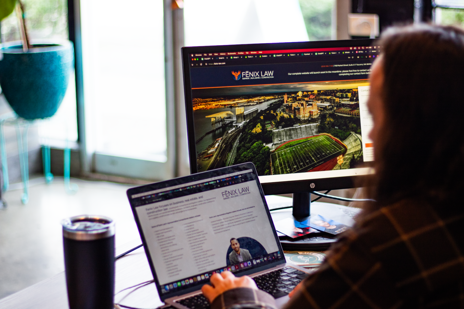 A website design open on a monitor and laptop at a Strategy 3 desk
